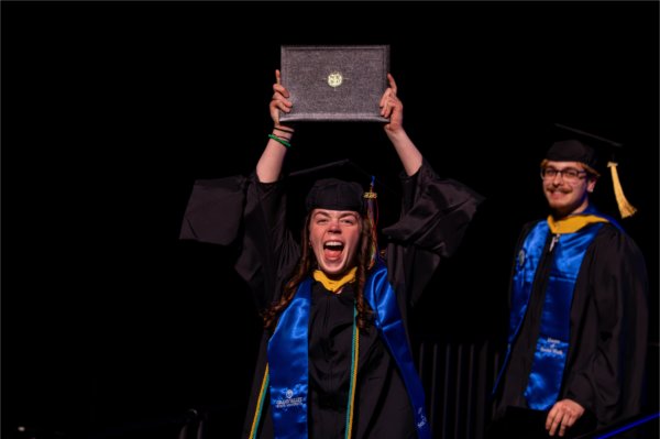 A masters graduate celebrates after receiving their diploma during the Commencement ceremony at Van Andel Arena Friday, May 1.