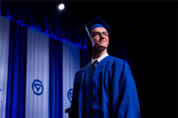 A graduate walks across the stage after receiving their diploma during the Commencement ceremony at Van Andel Arena Friday, May 1.