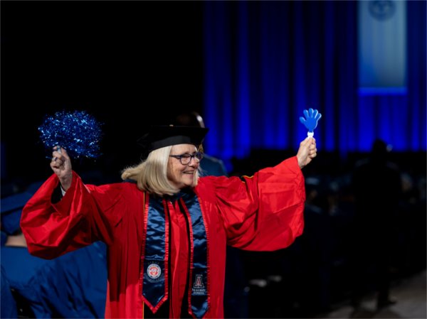 Vice chair of faculty senate and professor of accounting, Anne Sergeant, peps up the graduates as they recess out of Saturday morning&#8217;s Commencement ceremony at Van Andel Arena May 2.
