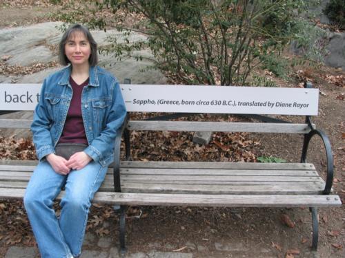 Diane Rayor, professor of classics, poses with a bench in New York City depicting a piece of translated Sappho text from her book "Sappho: A New Translation of the Complete Works."