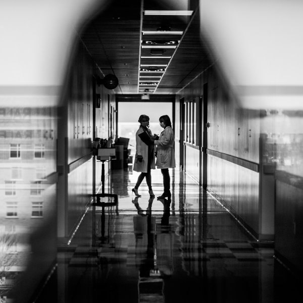 two people in a hallway of CHS, can see Finkelstein Hall out the windows