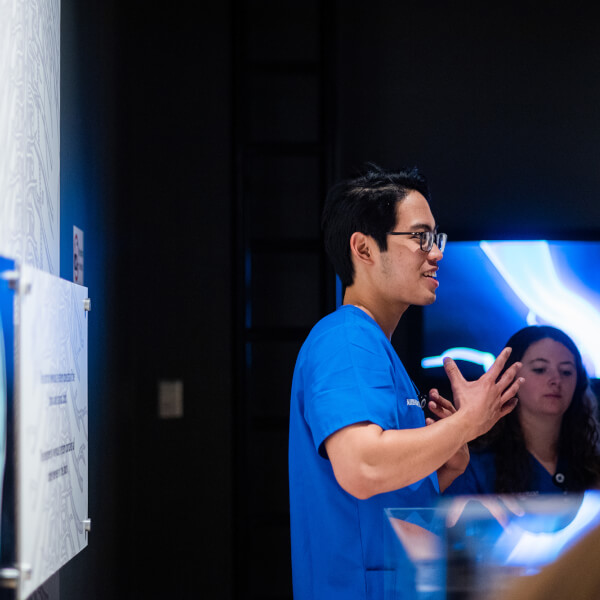 nursing student talks with museum guests at exhibition