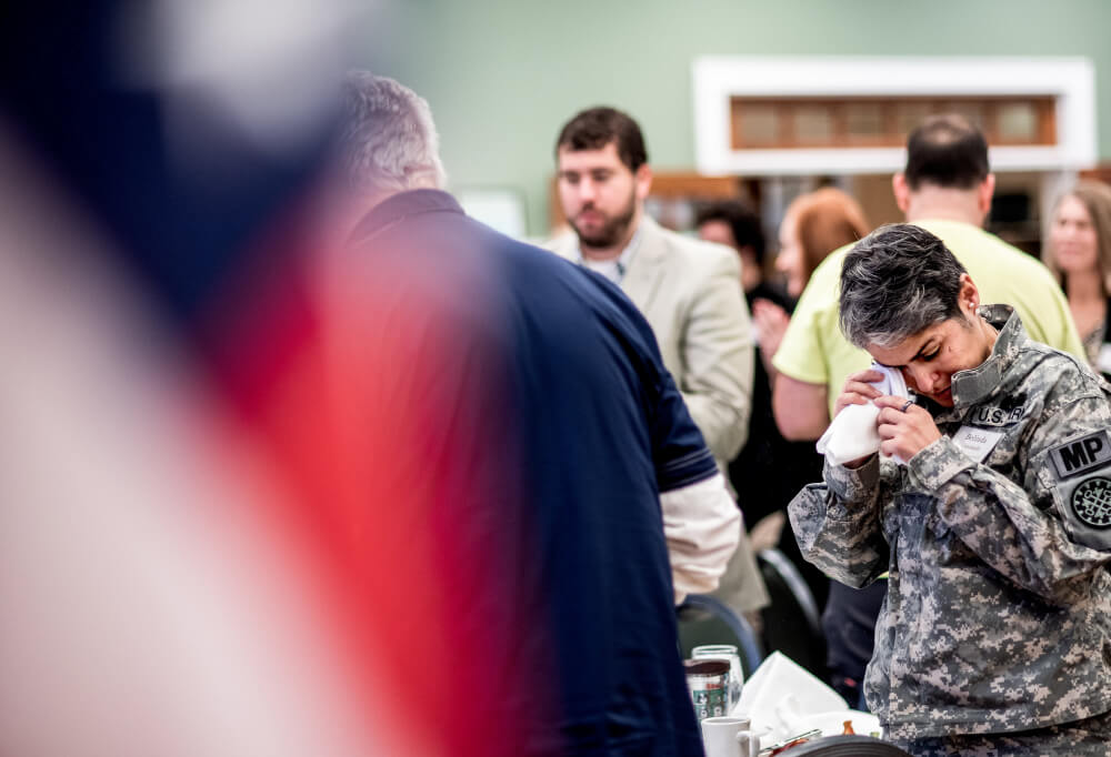 Belinda Coronado wipes a tear during the singing of the national anthem.