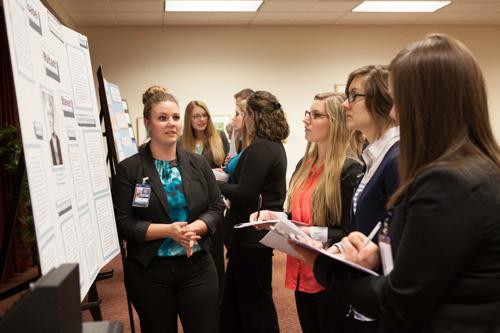 Nursing students present posters that focus on notable nurses in the Cook-DeVos Center for Health Sciences. Pictured is Jessica Santi.