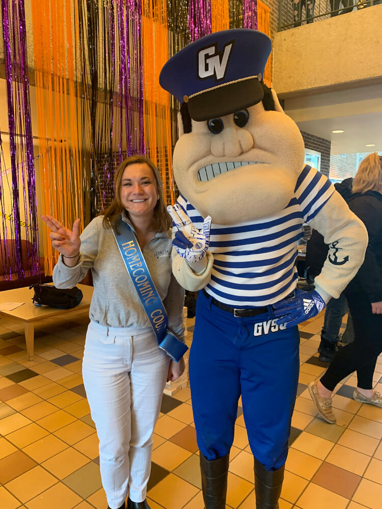 student standing with Louie the Laker