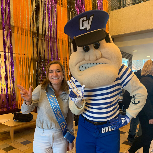 student standing with Louie the Laker