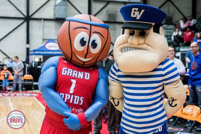 A photo of Louie and the Laker and the Grand Rapids Drive's mascot.