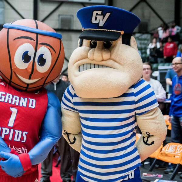 A photo of Louie and the Laker and the Grand Rapids Drive's mascot.