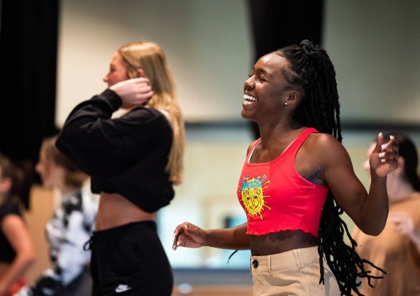 A college student laughs while dancing in a hop hop class.