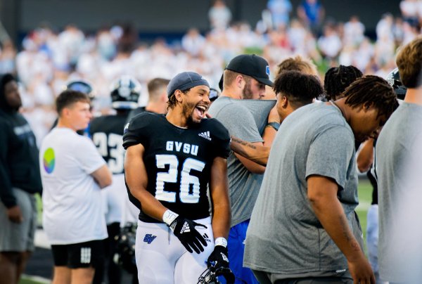  A college football player laughs along the sidelines during a game.