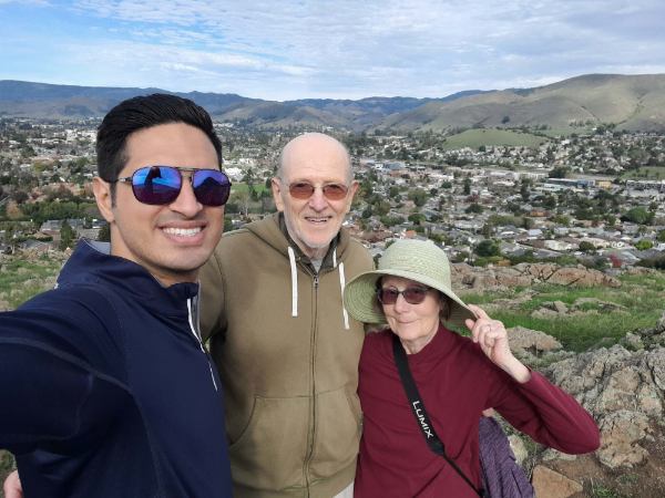 Farhad Kadkhodazadeh, Jim and Virginia Goode stand in front of a mountain background