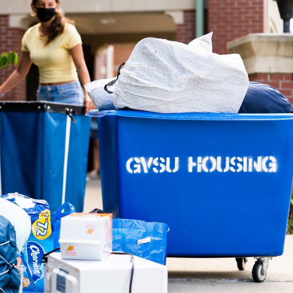 Blue bins that say GVSU housing. Filled with student's belongings.