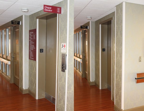 Signs above and by elevators in a hallway used for wayfinding.