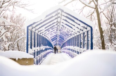 Students walk across the blue Little Mac Bridge amongst the results of a recent snowfall.