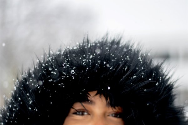  Snowflakes stick to the furry black hood of a college student's coat. 