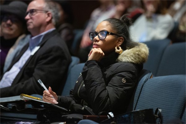  An audience member listens intently to a speech. 