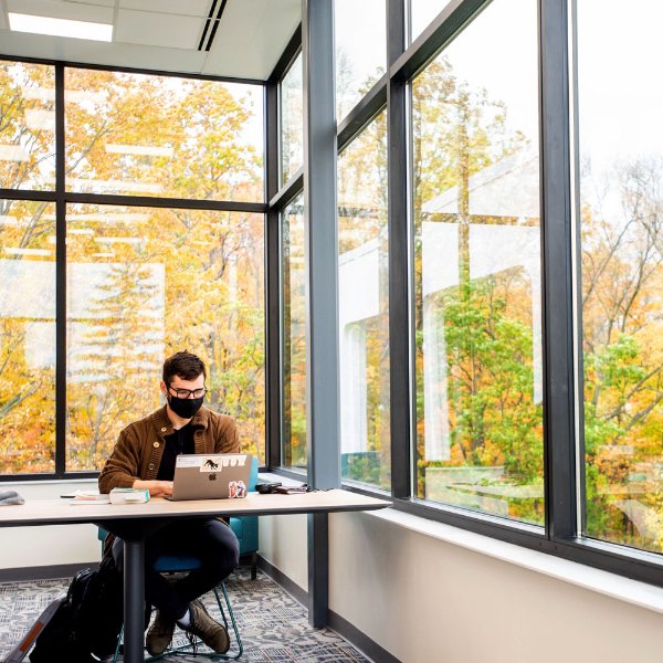 A student studying in a newly renovated area of Lake Huron Hall.