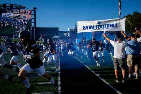 The Grand Valley football team runs on to the field.