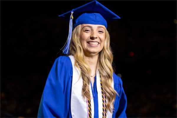A person wearing a cap and gown wears a great big smile. 