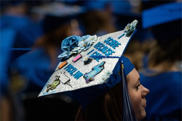 Close up view of a decorated cap that says, "I scare because I care. PICU, RN".