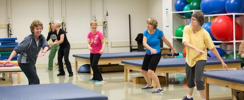 Cathy Harro, far left, leads people through exercise routines during a PowerUP class at the Cook-DeVos Center for Health Sciences.
