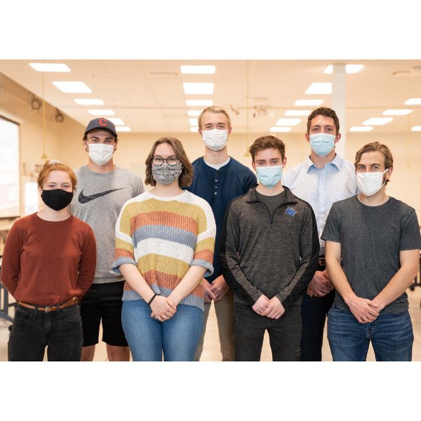 seven students in masks, in two rows, posing for a photo