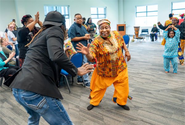 Jewellynne "Mama Jewel" Richardson, center, dances with Torrey Thomas, Human Resources Administrative Assistant, as Richardson performs with her group, West Michigan Jewels of Africa, as part of a Juneteenth Celebration at the Kirkhof Center on June 18.