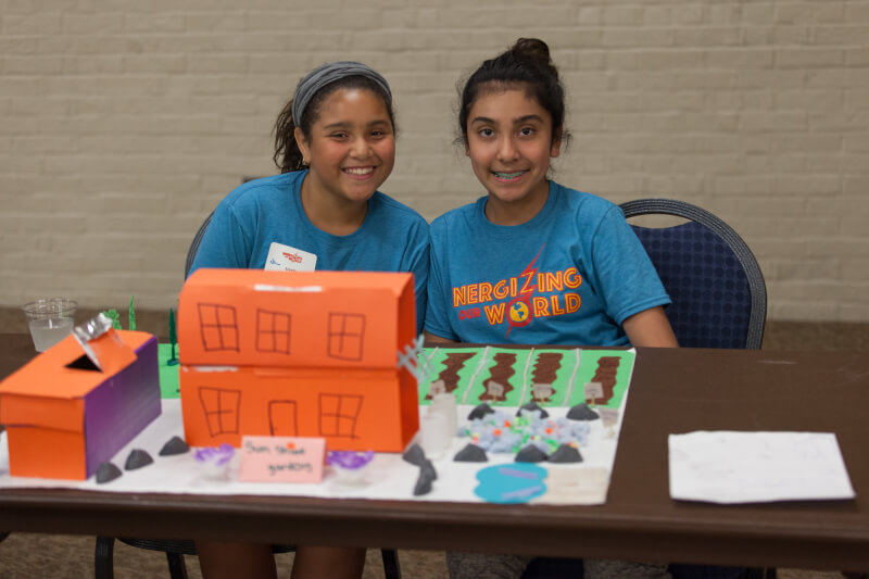 Campers showcasing their solutions to the question, "How might we make our homes more energy independent?" These campers created a sustainable farm home complete with a solar oven, compost pile and rain barrels.