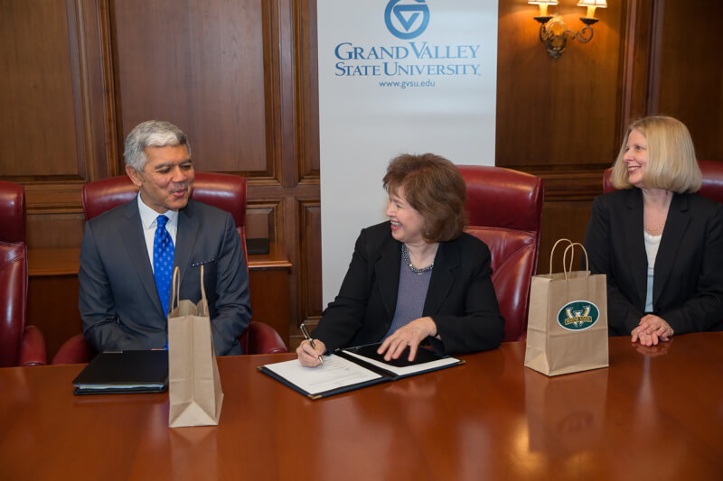 from left, signing agreement with two women and one man