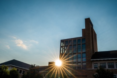 The sun shines through the Seidman College of Business building.