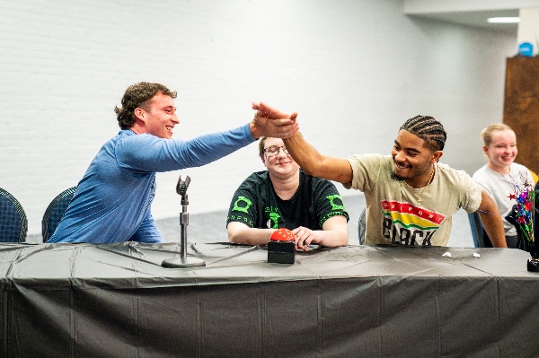  Two college students high-five during a quiz bowl challenge. 