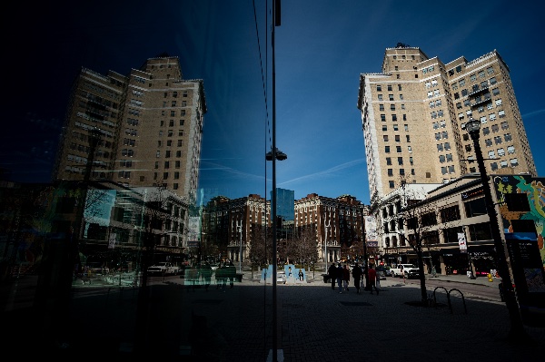  A city skyline is reflected in a glass storefront. 