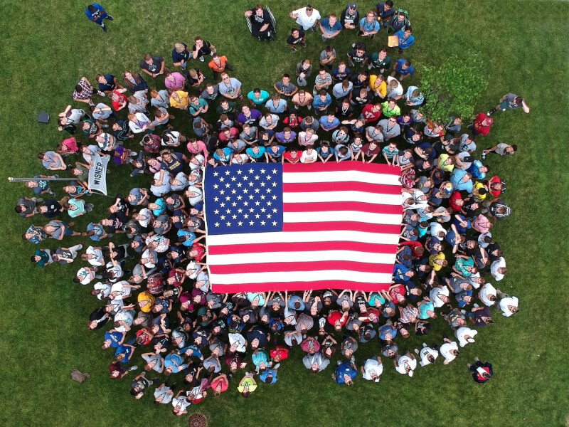 A group of high school seniors holds up an American flag during Boys State, a mock government exercise that was held at Grand Valley State University.