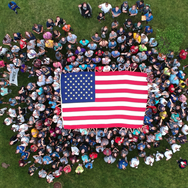 A group of high school seniors holds up an American flag during Boys State, a mock government exercise that was held at Grand Valley State University.