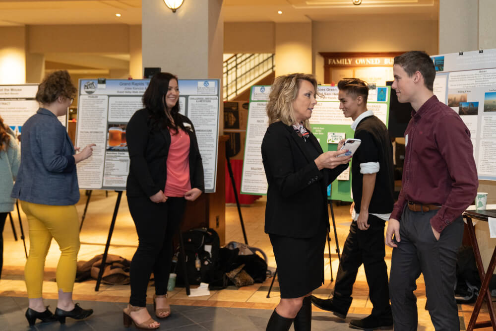 A photo of a student presenting research at the CCPS symposium.