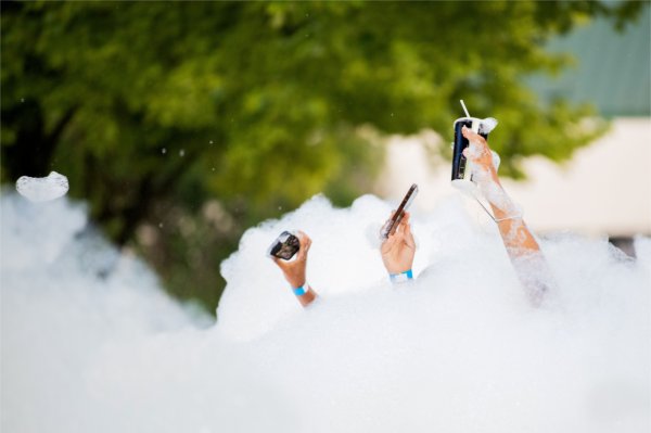 Students take selfie photos of themselves as they play in a foam pit during Laker Kickoff.