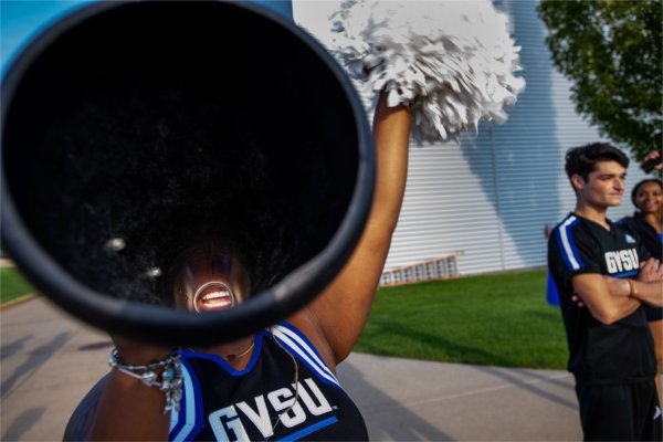 The inside of a megaphone held by a cheerleader, showing their excited smile.