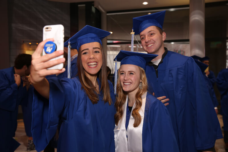 three graduates taking selfie