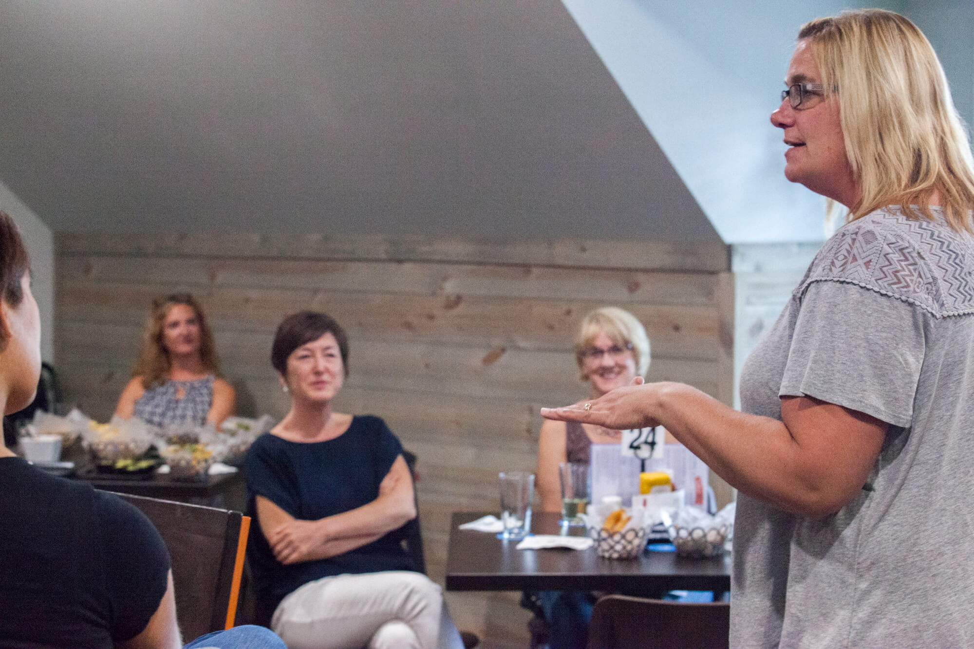 woman addressing people at a restaurant