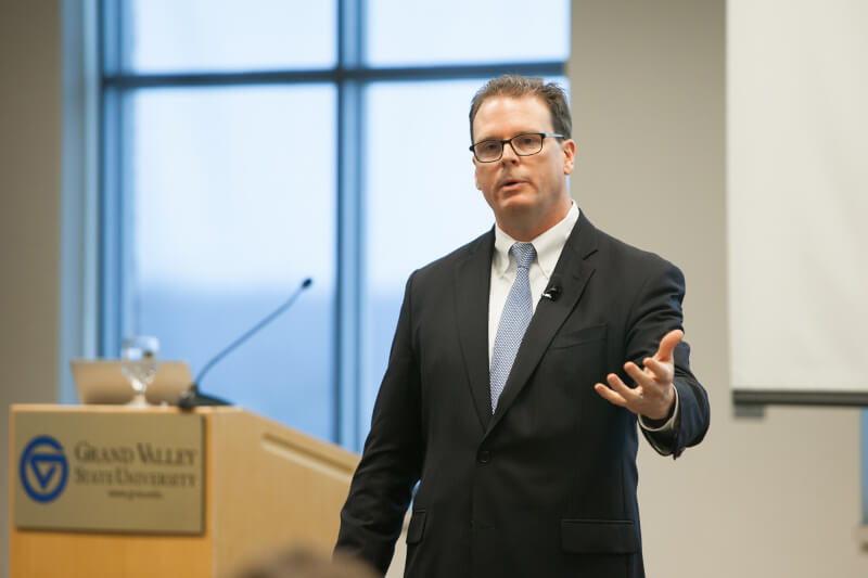 Man speaking in front of podium to audience