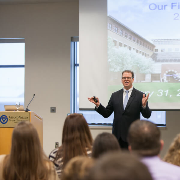 Man in front of podium speaking to audience