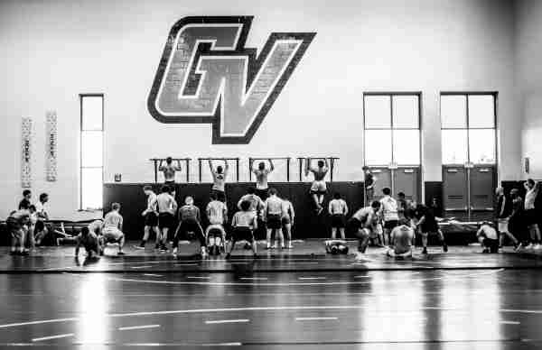 College wrestling athletes workout during practice.  