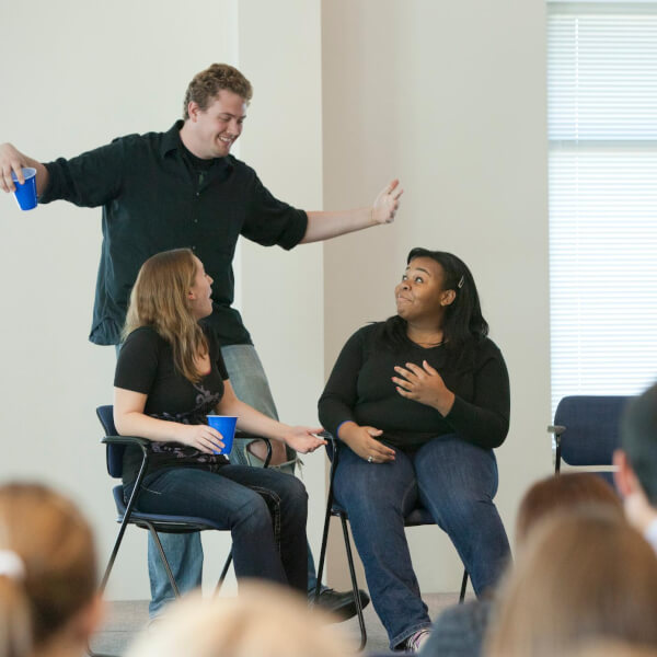 Photo of React troupe performing for students.