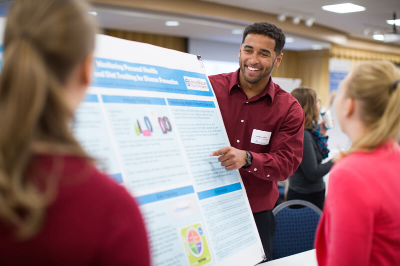 group of students looking at a poster