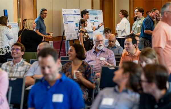 Guest settle into their seats while students discuss their research with visitors prior to the start of the Student Scholar Showcase.
