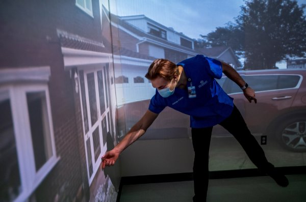 A nursing student touches the interactive wall in the virtual reality lab.
