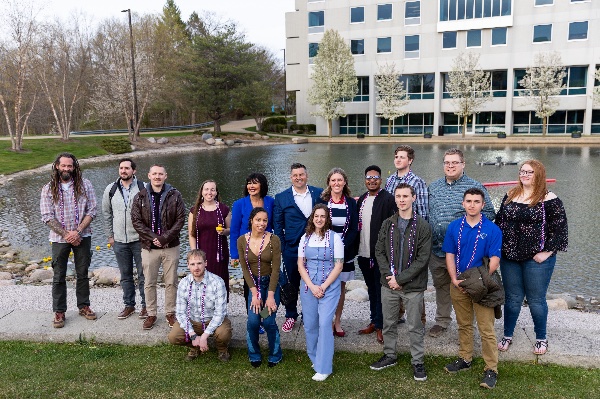 Student veterans and service members who are preparing to graduate gather with President Mantella in front of Zumberge pond for a "senior sendoff" that included floating rubber ducks on the pond.