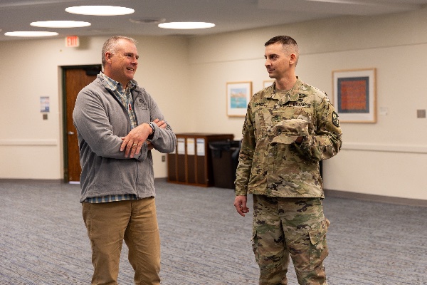 Two people talk at the celebration for military veterans who are graduating.