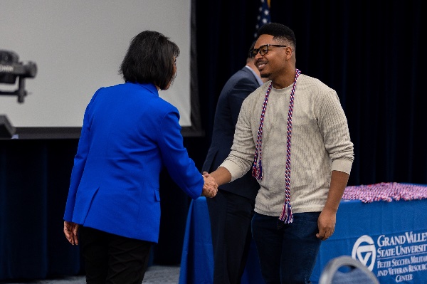 President Mantella shakes hands with a student veteran who is preparing to graduate.