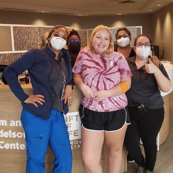 Annabelle Kopcan stands with nurses, in masks, at a clinic after donating stem cells.